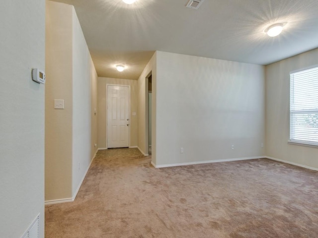empty room featuring baseboards, carpet flooring, and visible vents