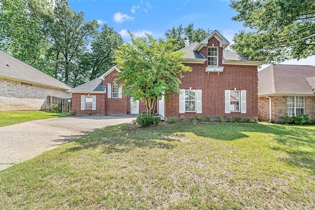 view of front of property featuring fence, roof with shingles, a front lawn, brick siding, and driveway