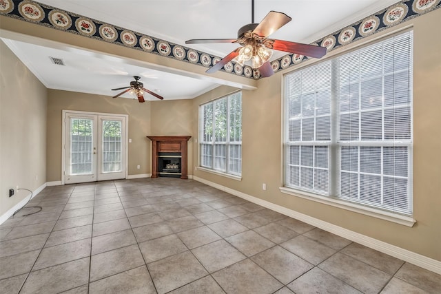 unfurnished living room with crown molding, baseboards, ceiling fan, and light tile patterned floors