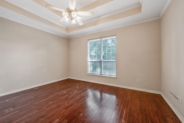 unfurnished room featuring a raised ceiling, ceiling fan, baseboards, and dark wood-type flooring