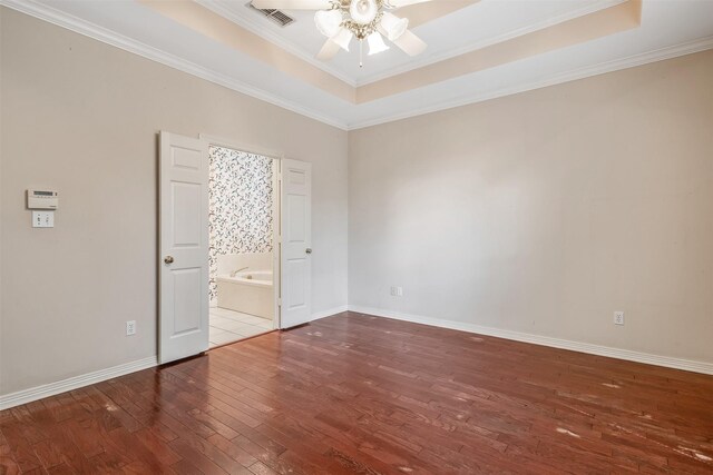 unfurnished bedroom featuring visible vents, crown molding, hardwood / wood-style floors, baseboards, and a raised ceiling