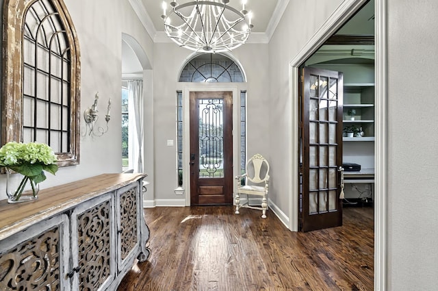 entrance foyer with crown molding, arched walkways, a chandelier, baseboards, and dark wood-style floors