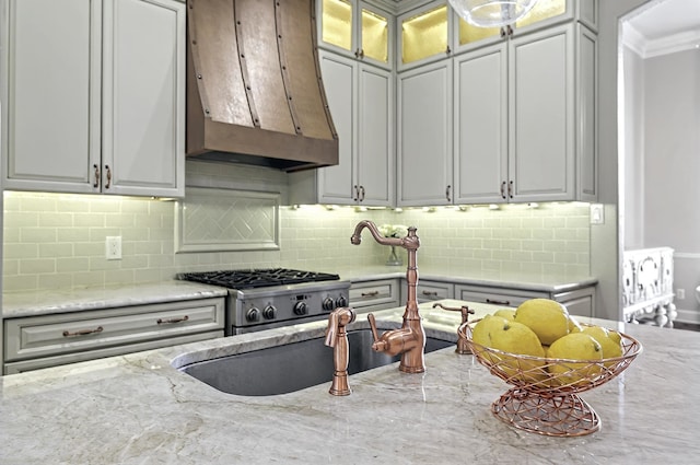 kitchen with light stone countertops, range, extractor fan, and tasteful backsplash