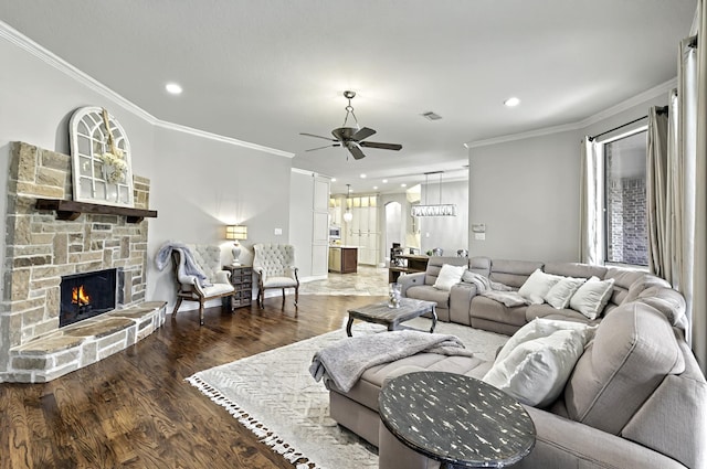 living room featuring ceiling fan, ornamental molding, wood finished floors, and a fireplace