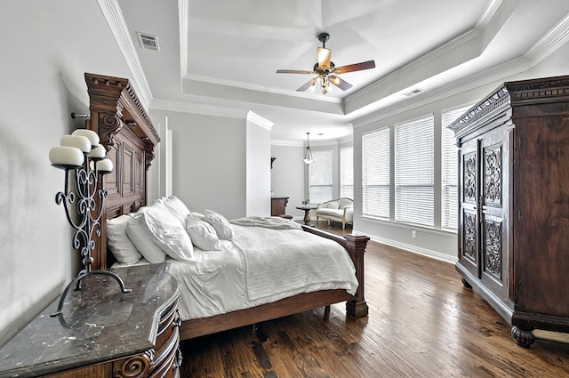 bedroom featuring visible vents, a raised ceiling, baseboards, and dark wood-style floors