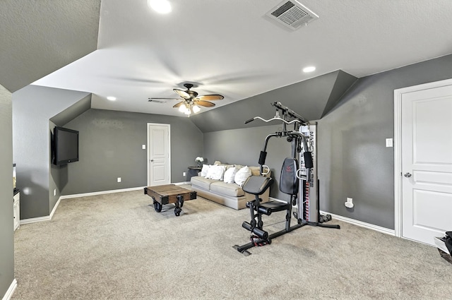 exercise area with visible vents, baseboards, ceiling fan, carpet flooring, and vaulted ceiling