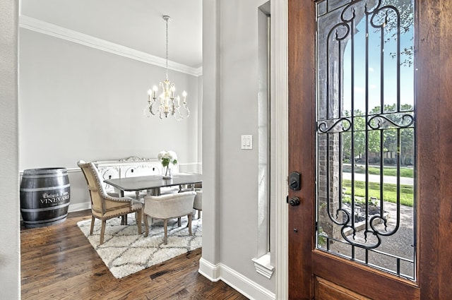 foyer entrance featuring baseboards, ornamental molding, dark wood finished floors, and a notable chandelier