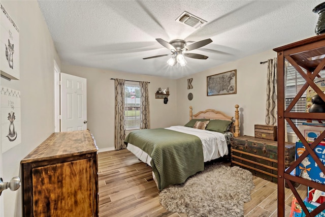 695 SE 32nd St, Paris, TX 75460 - bedroom with visible vents, a textured ceiling, ceiling fan, and light wood-type flooring