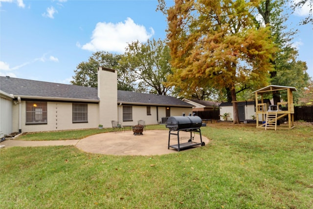 695 SE 32nd St, Paris, TX 75460 - back of property featuring an outdoor fire pit, a fenced backyard, a chimney, a patio, and a yard