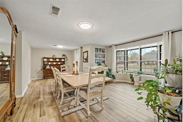 695 SE 32nd St, Paris, TX 75460 - dining room featuring a textured ceiling, baseboards, light wood-style flooring, and visible vents