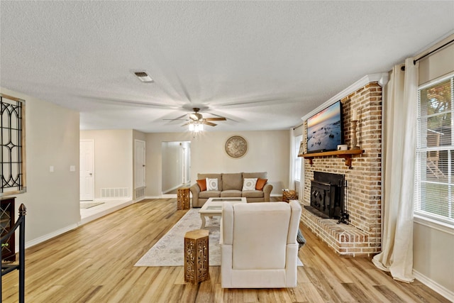 695 SE 32nd St, Paris, TX 75460 - living area with baseboards, light wood-style flooring, a textured ceiling, and plenty of natural light
