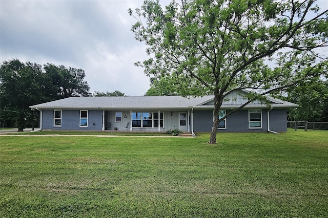 single story home with brick siding, fence, and a front lawn
