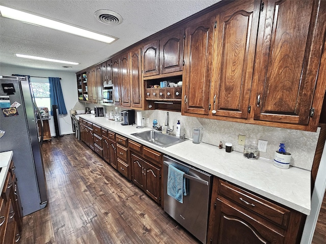 kitchen featuring a textured ceiling, visible vents, appliances with stainless steel finishes, a sink, and light countertops