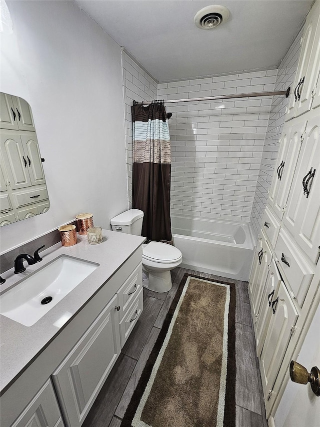 bathroom featuring vanity, shower / bath combo with shower curtain, toilet, wood finished floors, and visible vents
