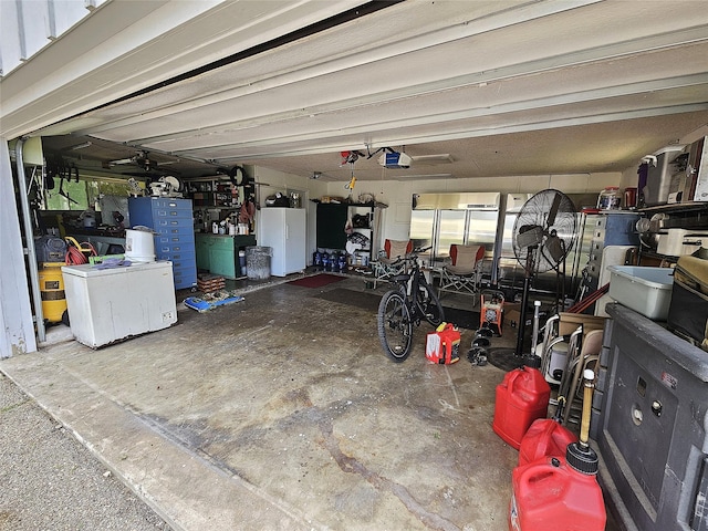 garage featuring a garage door opener and freestanding refrigerator