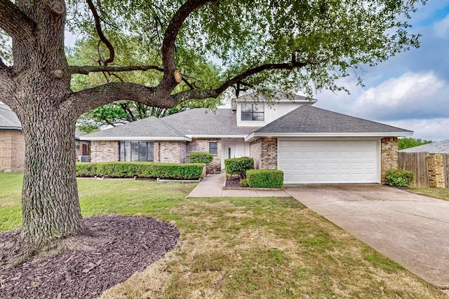 view of front of home featuring a front lawn, fence, brick siding, a shingled roof, and concrete driveway