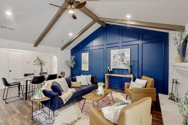 living room with visible vents, lofted ceiling with beams, wood finished floors, and a decorative wall