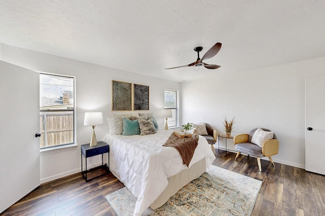 bedroom with a ceiling fan, baseboards, and dark wood-style floors