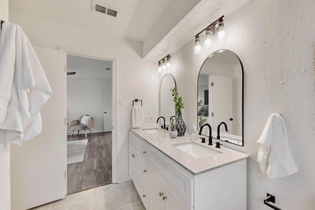 full bath featuring double vanity, visible vents, a sink, and tile patterned flooring