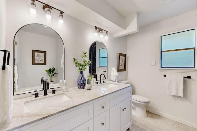 bathroom featuring tile patterned flooring, a sink, double vanity, and toilet
