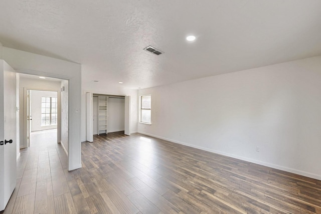 unfurnished bedroom with baseboards, dark wood-style flooring, and multiple windows