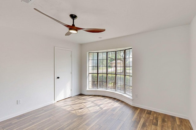spare room featuring baseboards, a ceiling fan, and wood finished floors