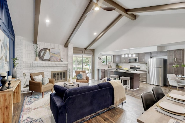 3965 Singleleaf Ln, Fort Worth, TX 76133 - living area featuring beamed ceiling, light wood-style floors, ceiling fan, a fireplace, and high vaulted ceiling
