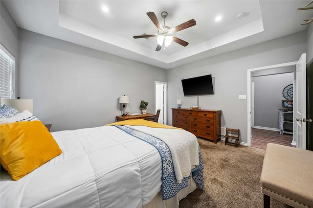 carpeted bedroom featuring baseboards, a ceiling fan, a tray ceiling, and recessed lighting