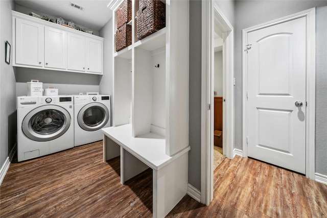 clothes washing area featuring independent washer and dryer, visible vents, dark wood finished floors, cabinet space, and baseboards