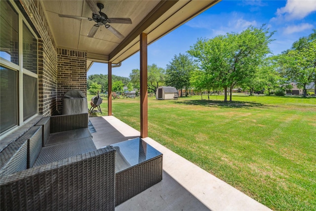 view of yard with a ceiling fan, an outdoor structure, a patio area, and a storage unit