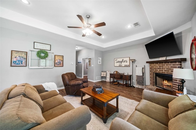 living room featuring a ceiling fan, visible vents, wood finished floors, and recessed lighting