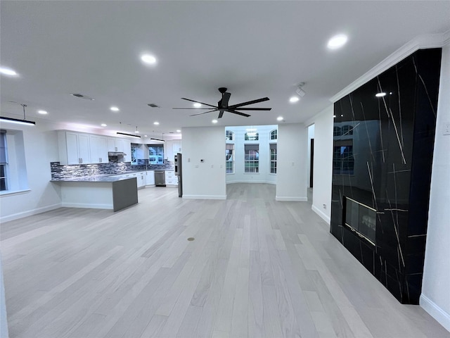 unfurnished living room with baseboards, light wood-type flooring, a ceiling fan, and recessed lighting