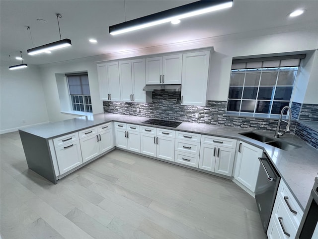 kitchen featuring a sink, dishwasher, black electric cooktop, a peninsula, and decorative backsplash