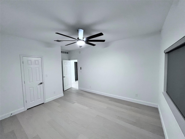 unfurnished bedroom featuring baseboards, visible vents, ceiling fan, and light wood-type flooring