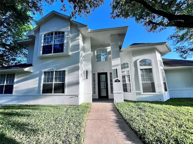 view of front facade with a front lawn and stucco siding