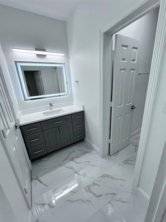 bathroom with vanity, marble finish floor, and baseboards