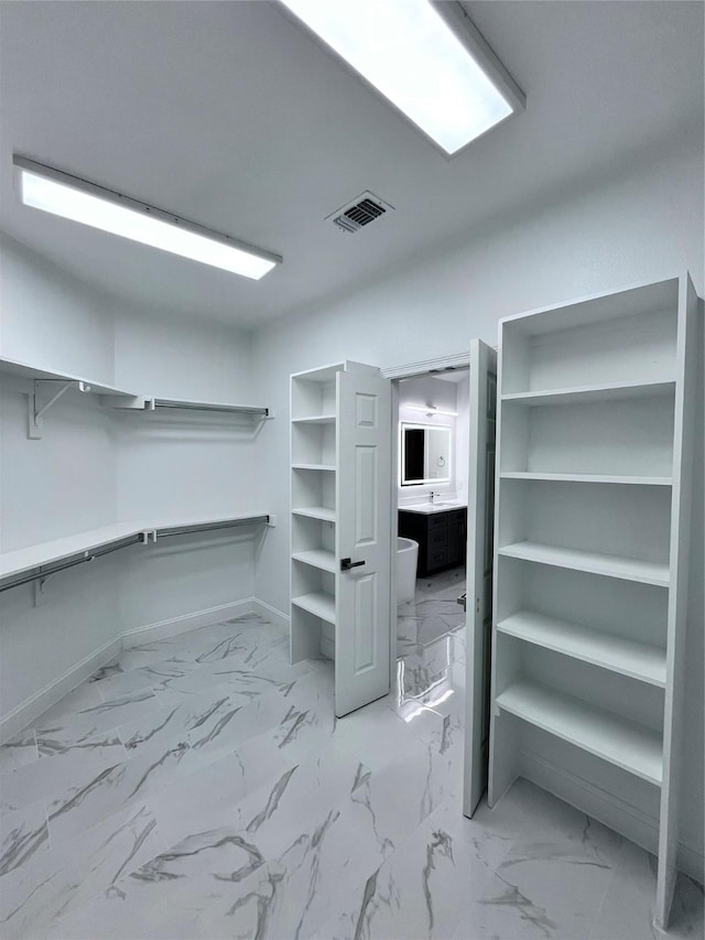 spacious closet with marble finish floor and visible vents