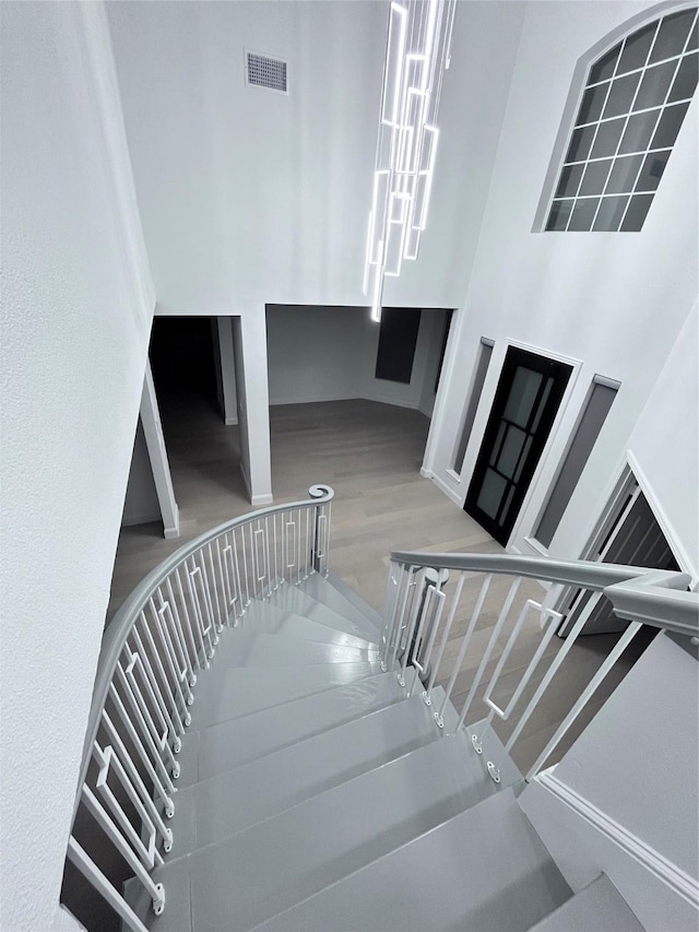 stairway featuring visible vents and wood finished floors