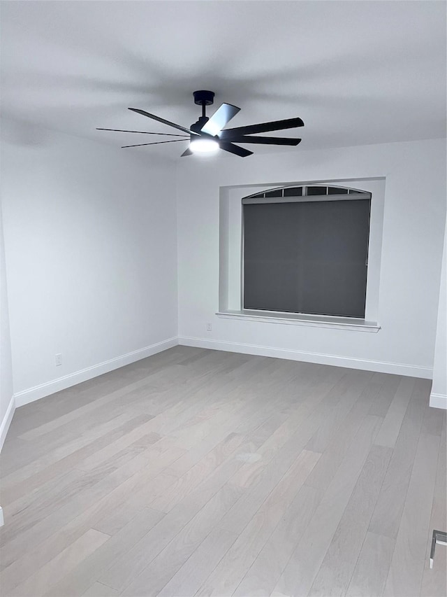 unfurnished room with baseboards, a ceiling fan, and wood finished floors