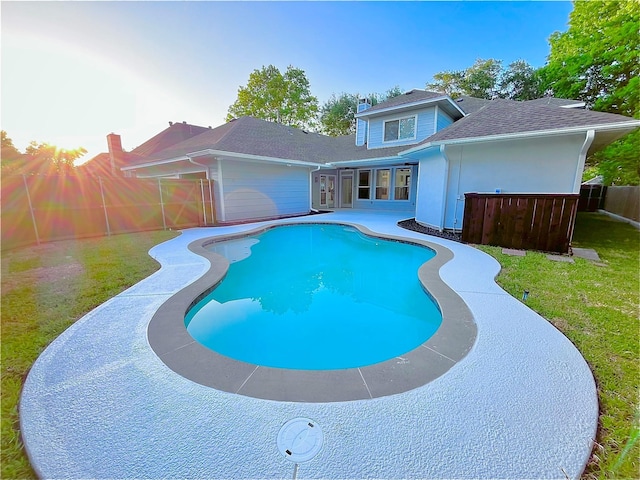 view of swimming pool featuring a yard, fence, a fenced in pool, and a patio