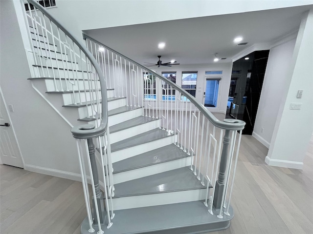 stairway with baseboards, a ceiling fan, and wood finished floors
