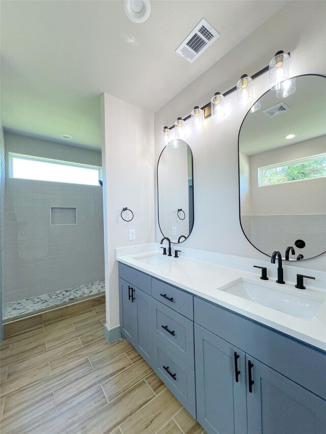 5008 San Marcos Dr, Granbury, TX 76048 - full bath with double vanity, a tile shower, and wood finish floors