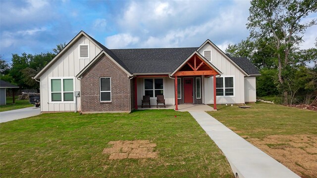 5008 San Marcos Dr, Granbury, TX 76048 - modern inspired farmhouse with board and batten siding, a front yard, roof with shingles, and brick siding
