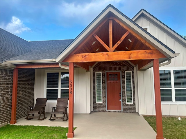 5008 San Marcos Dr, Granbury, TX 76048 - doorway to property with roof with shingles, board and batten siding, and brick siding