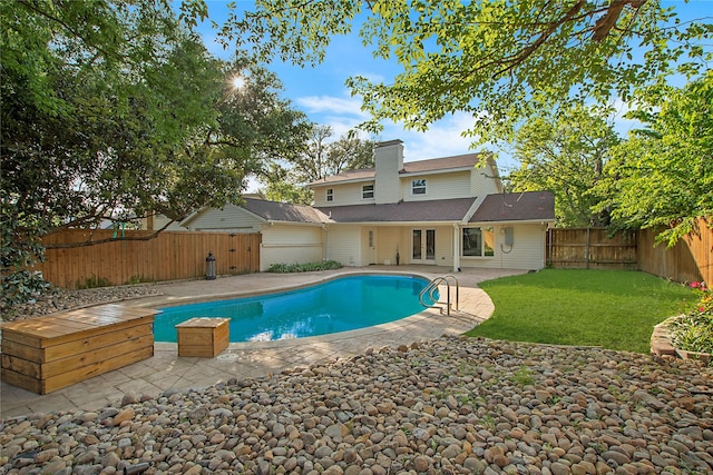 view of pool featuring a fenced backyard, french doors, a fenced in pool, a patio area, and a yard