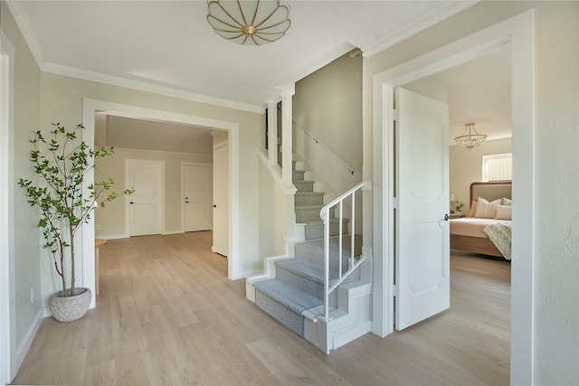 interior space with baseboards, ornamental molding, wood finished floors, and a notable chandelier