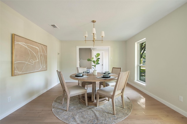 dining space with baseboards, light wood-type flooring, and visible vents