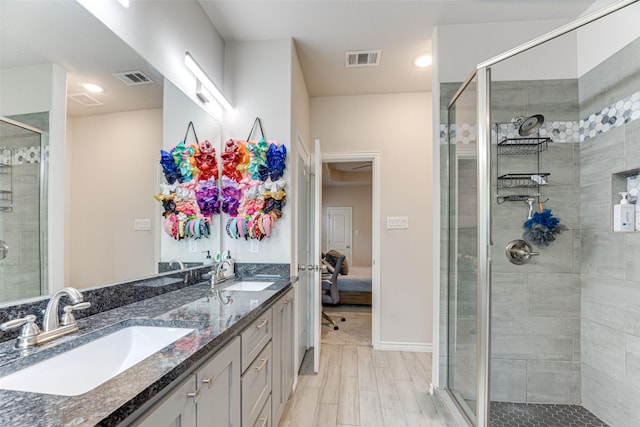 ensuite bathroom featuring a sink, a shower stall, and visible vents