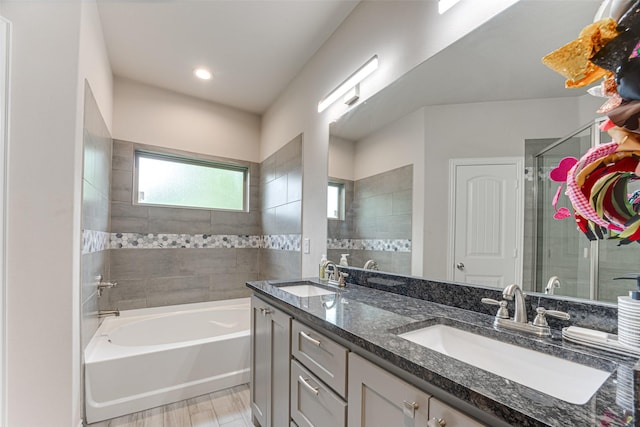 bathroom featuring double vanity, a sink, a bath, and tiled shower