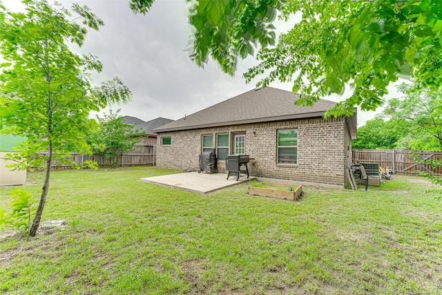 back of house with a patio, a fenced backyard, a lawn, and brick siding
